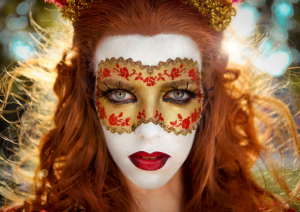 Rothaarige Frau mit Maske zum Thema Karneval
