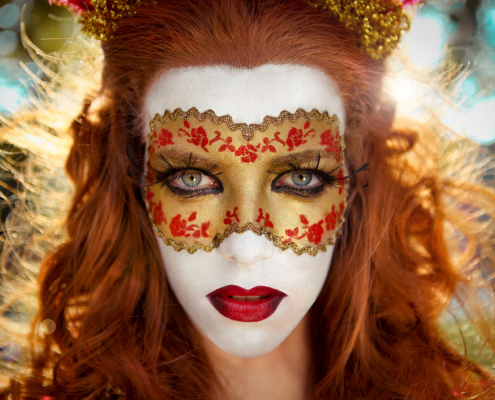 Rothaarige Frau mit Maske zum Thema Karneval