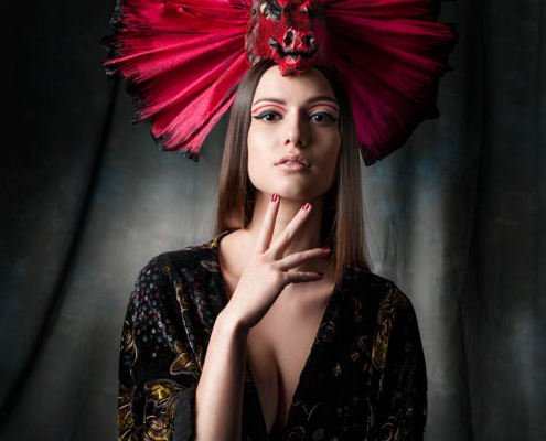 Make-Up Artist. Model mit rotem Kopfschmuck in japanischem Stil.
